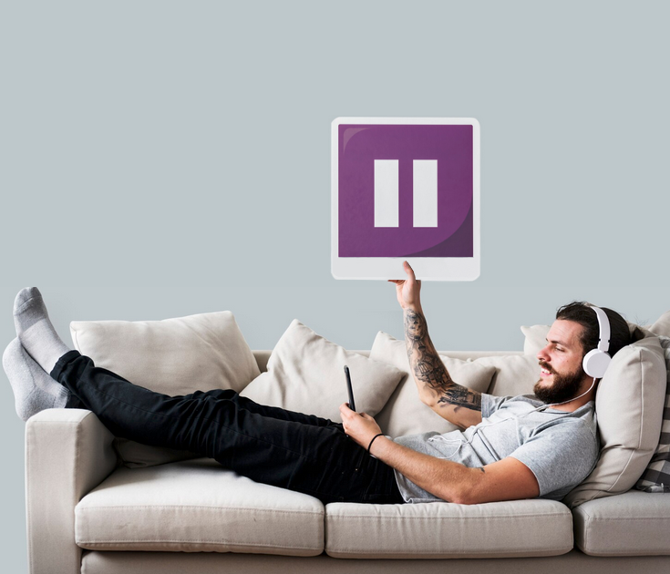 une page web s'affiche sur l'écran d'un ordinateur portable posé sur une table en bois. Un fauteuil, une table basse et une plante an arrière-plan.